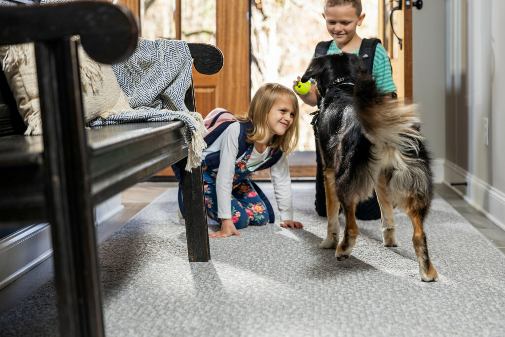 Kids plying with dog on carpet flooring | Westport Flooring and Interiors